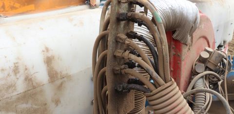 Les tuyaux sont branchés sur une platine installée sur le semoir à maïs. Cette dernière est placée sur celui à betteraves. Pour changer de semoir, Didier débranche les tuyaux de la platine. © P. Denis