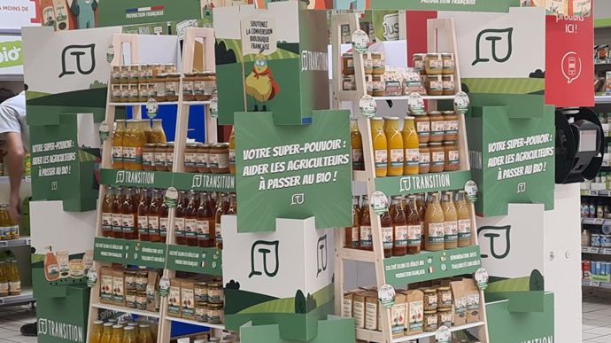 Chez Auchan, les produits Transition sont mis en avant dans les rayons bio sur des présentoirs en bois.