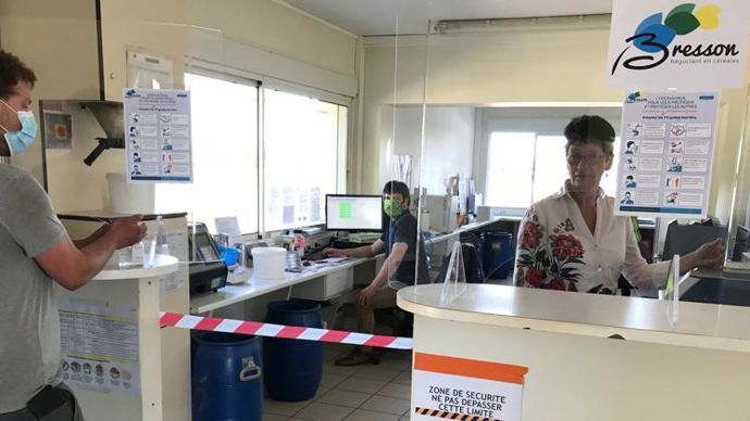 Catherine Racle et son fils Damien, à l’ordinateur, dans le local pont-bascule d’un des onze sites de leur négoce, avec Victor, agent de silo en train de se laver les mains au gel hydroalcoolique. La moisson se prépare chez Bresson qui s’est paré d’un nouveau logo, représentant un épi aux couleurs de l’air, du végétal et du soleil.