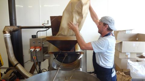 Atelier Graines de Bretons : Yoann Gouéry verse du sobacha dans le torréfacteur à grains. 