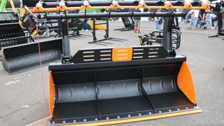 La barre striée fixée sur la machoire du godet Quicke permet de manipuler du bois sans abimer les dents.