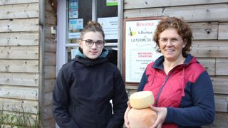 Agathe Planchez et Isabelle Deléglise avec une tomme et une mimolette produites sur place devant la boutique de la ferme du Wint, dans le Pas-de-Calais.