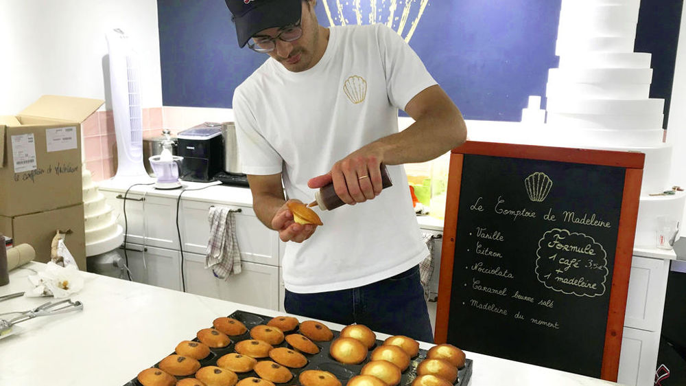 Quentin Hua en train de garnir ses madeleines chocolat-noisette.