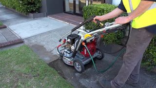 La machine possède à la fois une lance à haute pression et une rampe rotative pour nettoyer le sol.