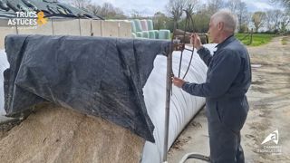 L'agriculteur pousse l'enrouleur au fur et à mesure de l'avancement du silo. L'agriculteur pousse l'enrouleur au fur et à mesure de l'avancement du silo.