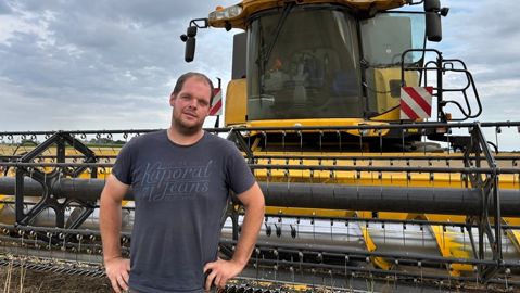 Alexis De Clerck jeune agriculteur dans l'Oise devant sa moissonneuse