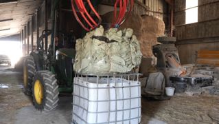 Les bottes de film d'enrubannage sont compressées avec le grappin de l'hydro-fourche du tracteur, ficelées, puis retirées du cubi. Les bottes de film d'enrubannage sont compressées avec le grappin de l'hydro-fourche du tracteur, ficelées, puis retirées du cubi.