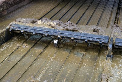 Racleur à lisier avec peignes en caoutchouc pour nettoyer les rainures des tapis