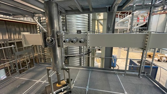 La colonne de descente des grains (verticale et cylindrique) permet d’exposer ces derniers aux ondes (via le guide d’ondes métallique et rectangulaire).