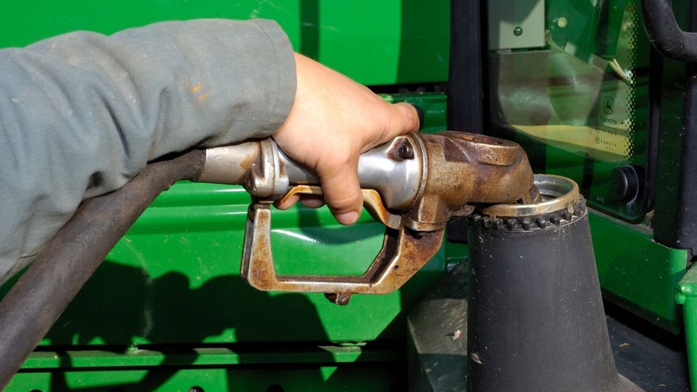 Agriculteur remplissant de GNR le réservoir d'un tracteur
