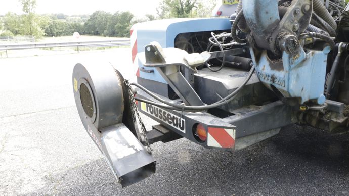 Le souffleur nettoie la chaussée après le passage de la machine.