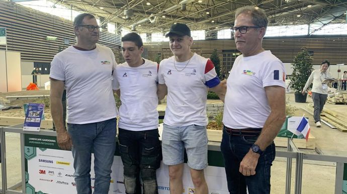 De gauche à droite : Thierry Kerguelin, expert métier international, les jardiniers paysagistes Thomas Costa et Julian Chenot, et Hervé Fonteneau, expert international adjoint, après la fin de la finale mondiale des WorldSkills.