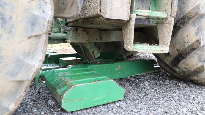 Le crochet du système d'attache vient se prendre dans le centre de la masse, c'est ensuite lui qui la remonte et la colle contre le chassis du tracteur.